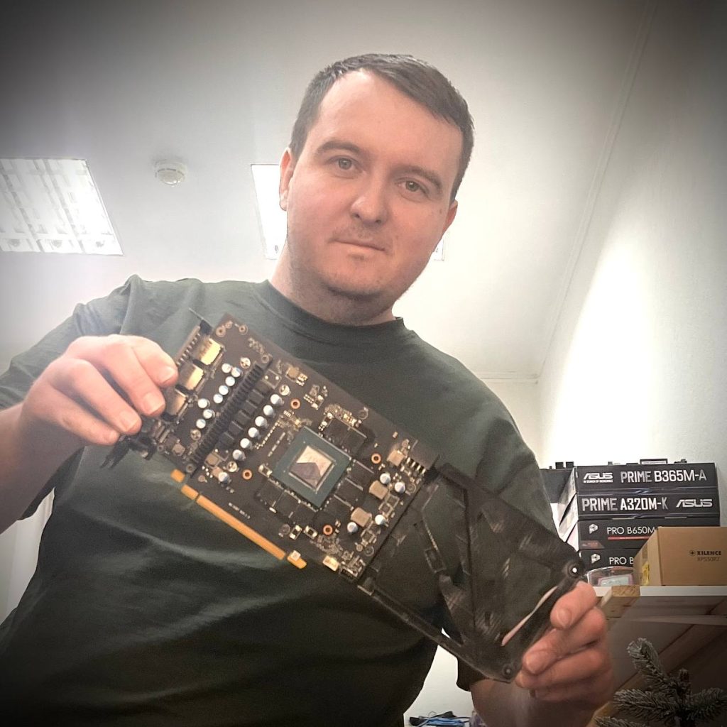 компьютерный мастер PChelper39 держит видеокарту